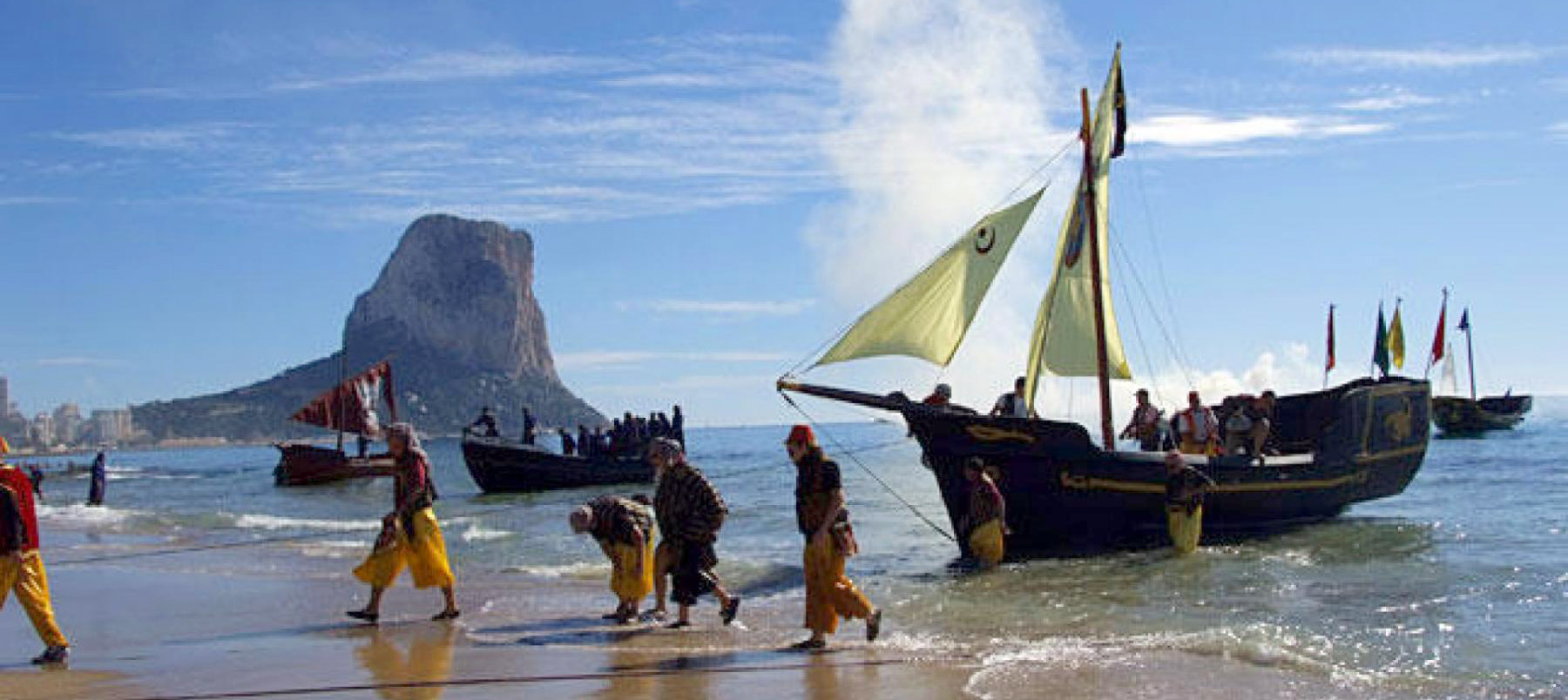 Calpe proudly reenacts the history confruntation between Moors and Christians as actors come ashore at Calpe beach, complete with boat!