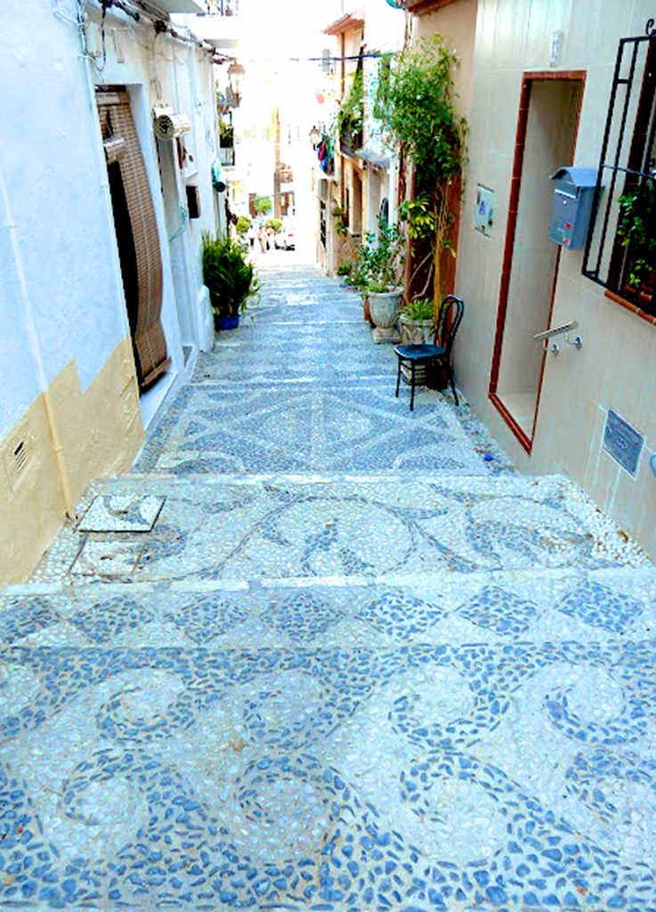 The cool mosaic tiles of a sleepy Calpe laneway on a sunny Costa Blanca day.